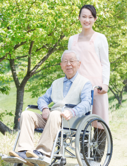 caregiver and patient in a wheelchair smiling